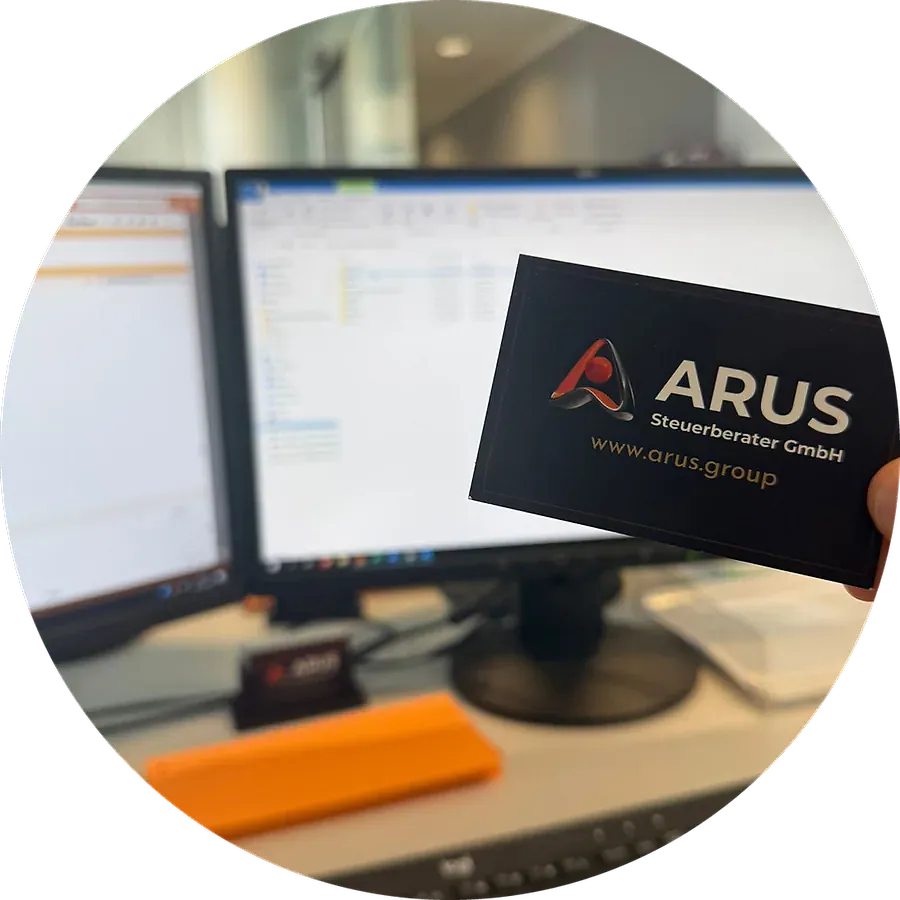 Visitenkarte der ARUS Steuerberater GmbH, vor einen Bildschirm gehalten